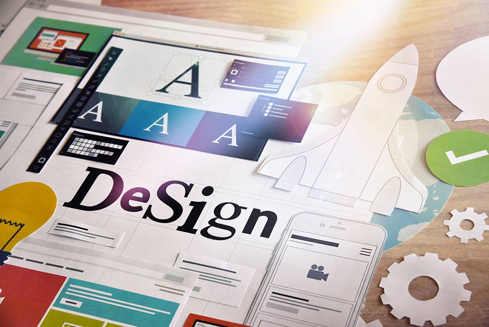 graphic designs on a table representing our expertise in branding and graphic design